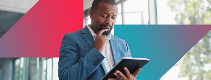 a man in a suit is looking at a tablet